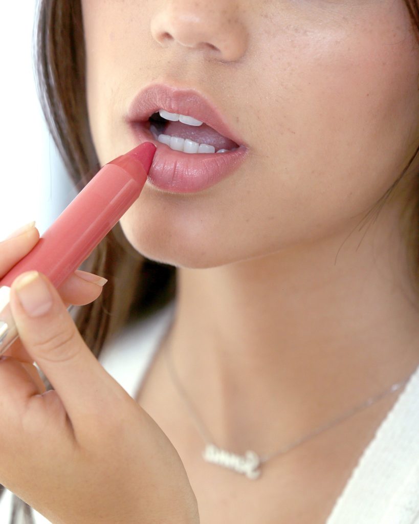 Jenna applying a Neutrogena product to her lips